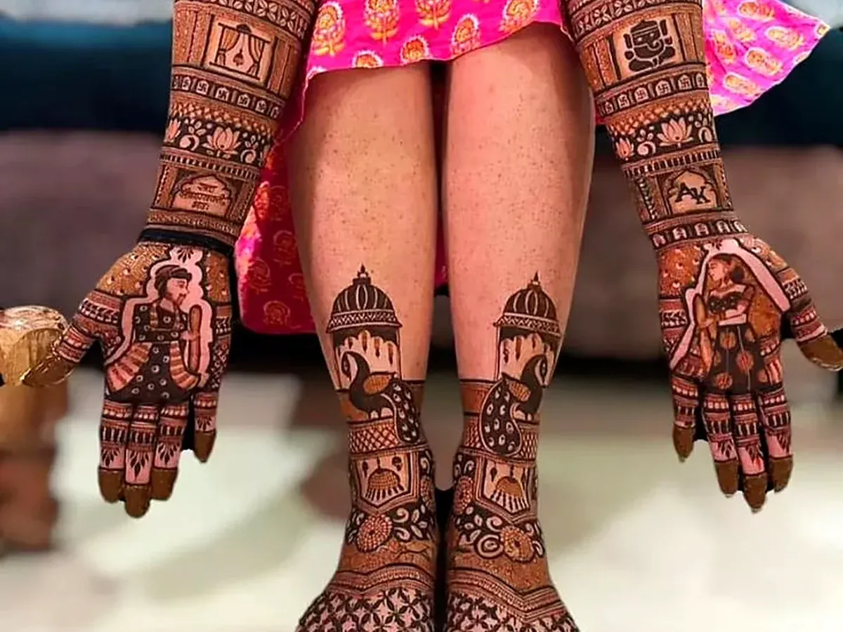 Complete bridal mehndi on both hands and feet with couple figures on the palms