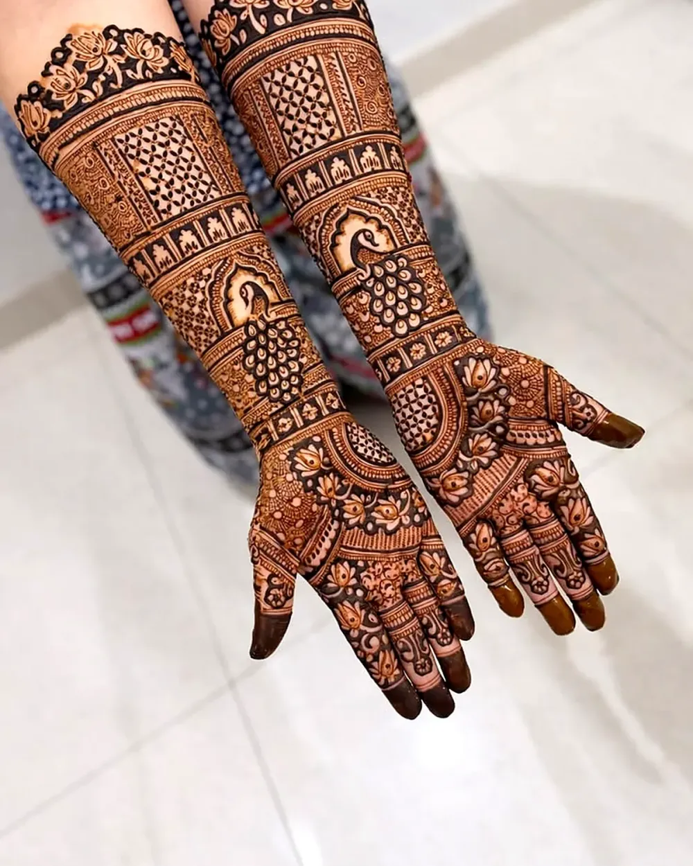 Bridal henna on full arms with lotus border and peacock on the palm