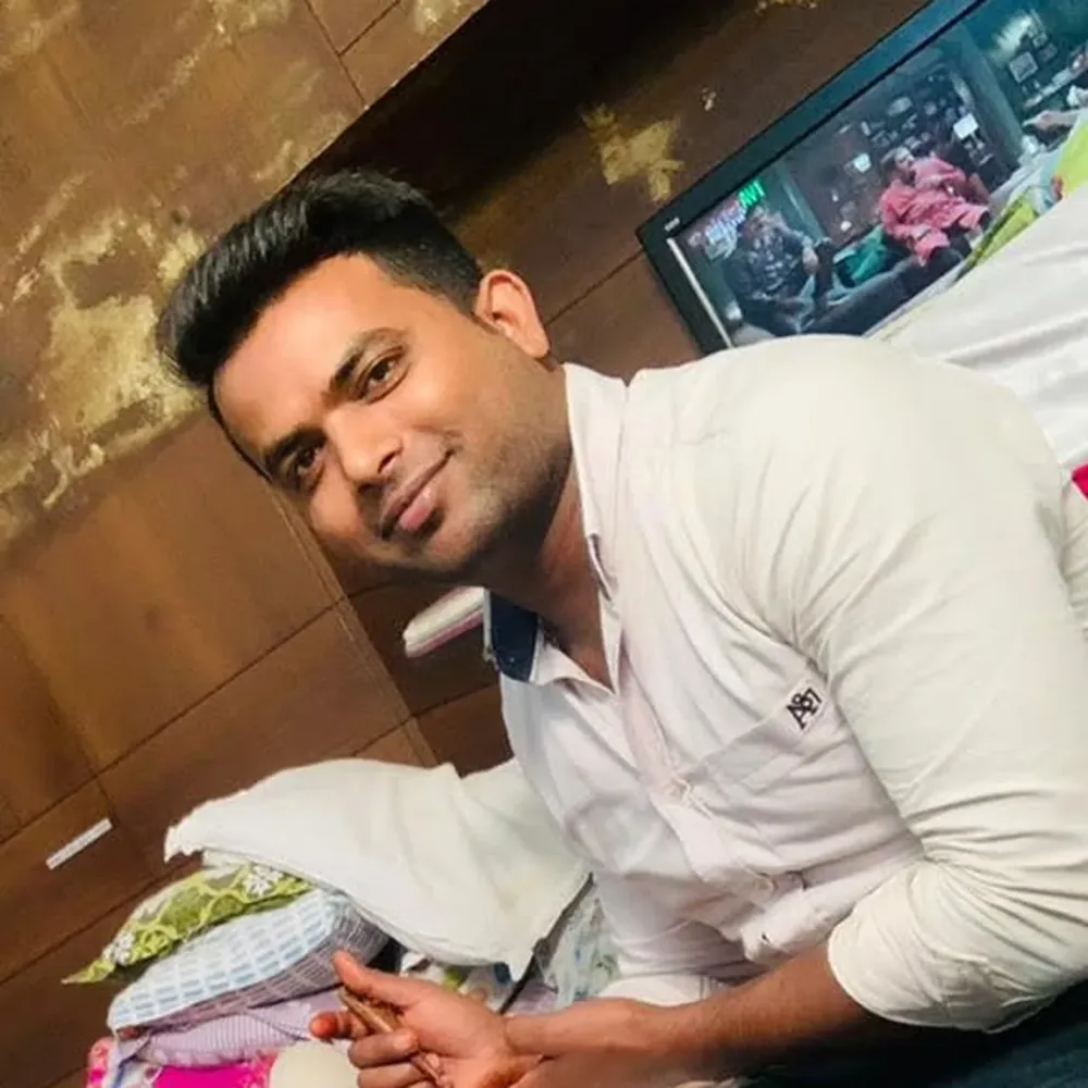 Vijay, mehndi artist in Chandigarh, smiling at a client's home while applying bridal mehndi